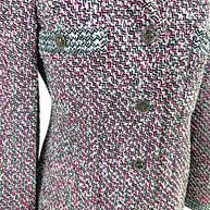 Detailed view of Chanel Spring 1996 tweed jacket showing signature CC medallion buttons and textured woven fabric