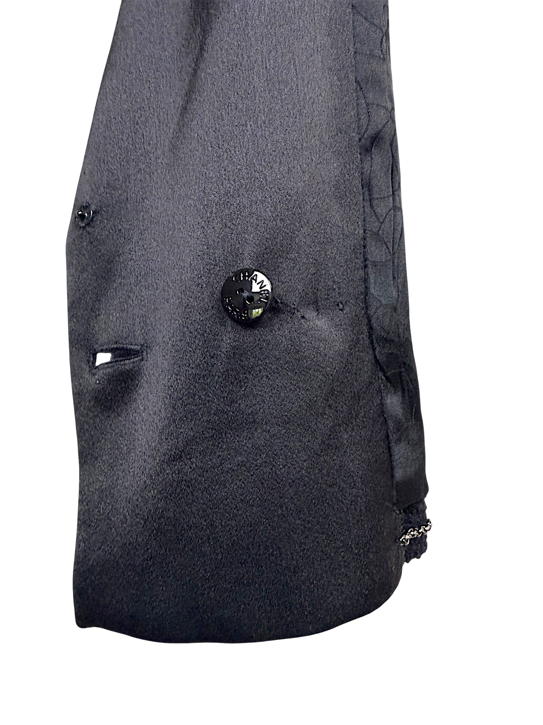 Interior construction detail showing authentic Chanel engraved button and luxury finishing inside the Spring Summer 2005 runway cropped tuxedo jacket.