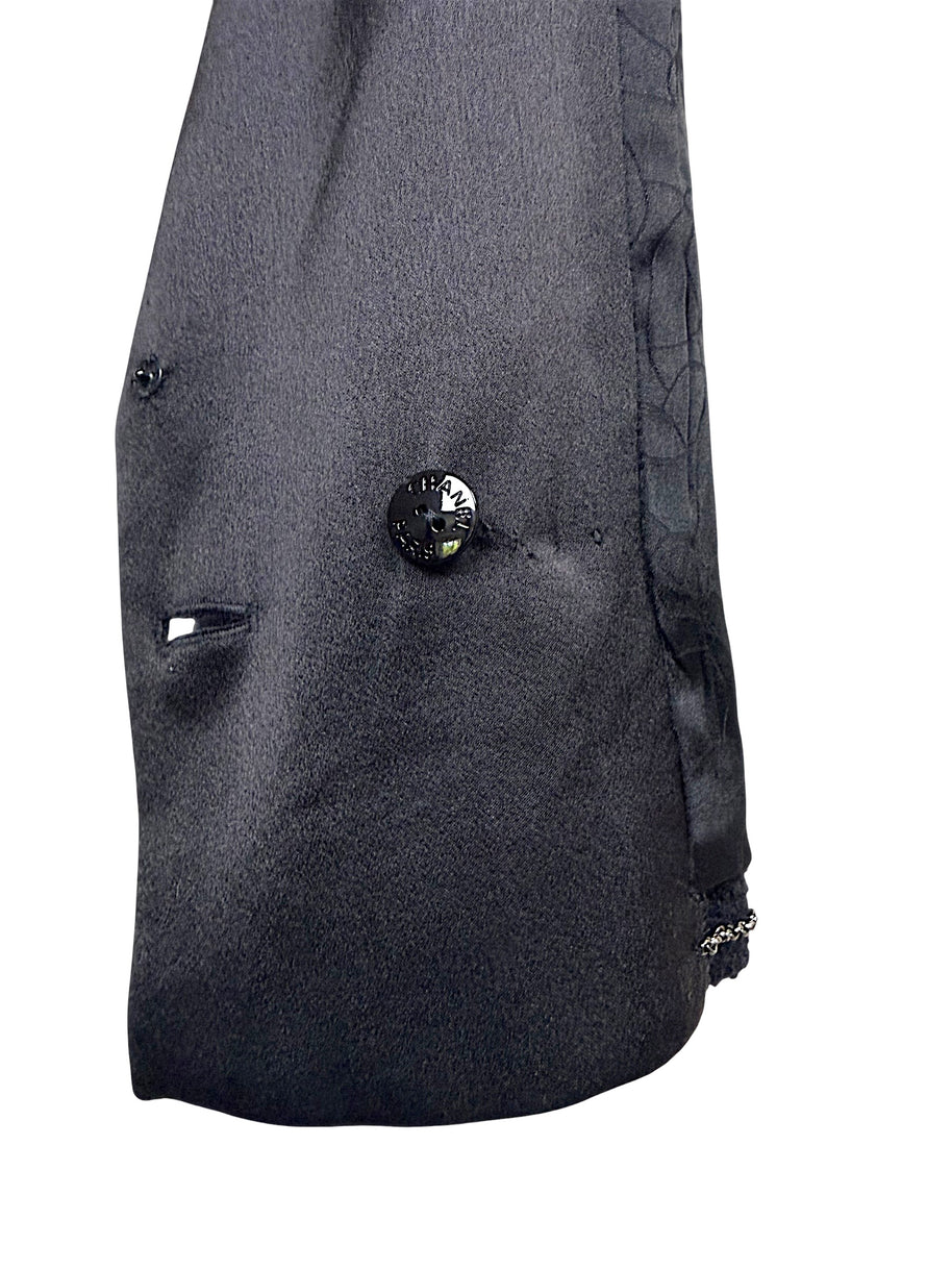 Interior construction detail showing authentic Chanel engraved button and luxury finishing inside the Spring Summer 2005 runway cropped tuxedo jacket.
