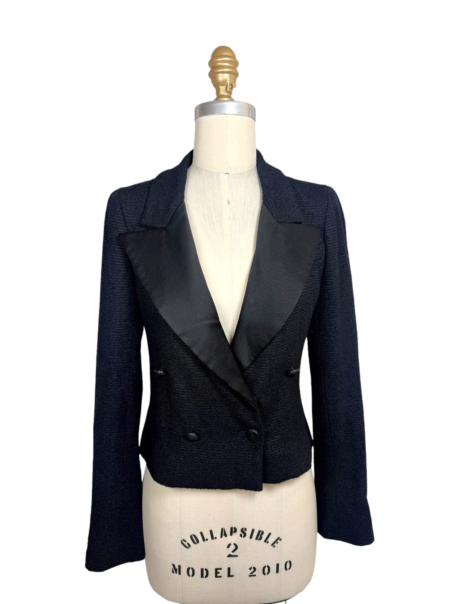 Documented Chanel Spring Summer 2005 runway black bouclé cropped tuxedo jacket featuring oversized satin peak lapels, double-breasted CC buttons and tailored silhouette.