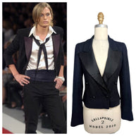 Side-by-side comparison of the documented Chanel Spring Summer 2005 runway look and the matching cropped black bouclé tuxedo jacket available for purchase.
