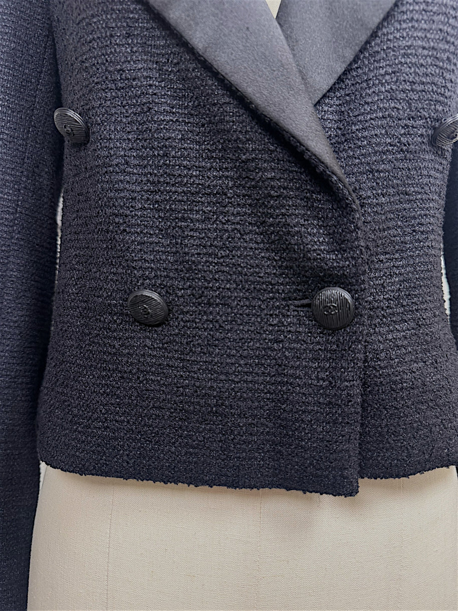 Close-up of the double-breasted front with engraved tonal CC buttons on Chanel Spring 2005 runway cropped tuxedo jacket.