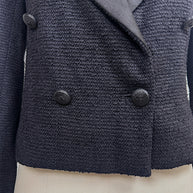 Close-up of the double-breasted front with engraved tonal CC buttons on Chanel Spring 2005 runway cropped tuxedo jacket.