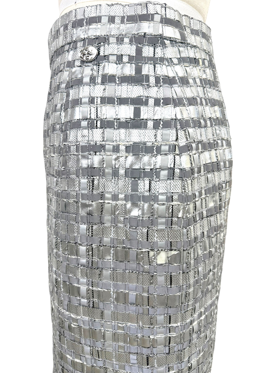 Detail of small mid hip area with missing metallic material on Chanel silver woven skirt.
