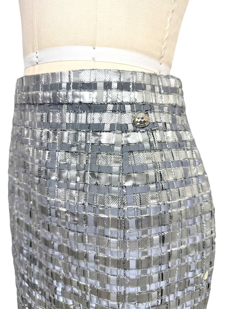 Close view of Chanel Spring 2016 silver metallic woven skirt waistband and logo button.