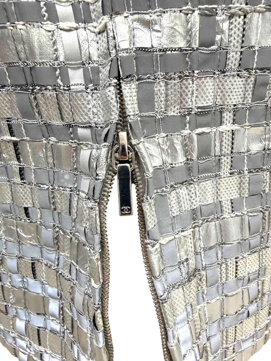Close view of Chanel CC zipper pull on silver metallic woven pencil skirt.