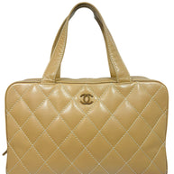 Vintage Chanel Surpique Bowler bag from the 2002–2003 collection in beige quilted lambskin leather with contrast stitching and gold CC logo detail front view.