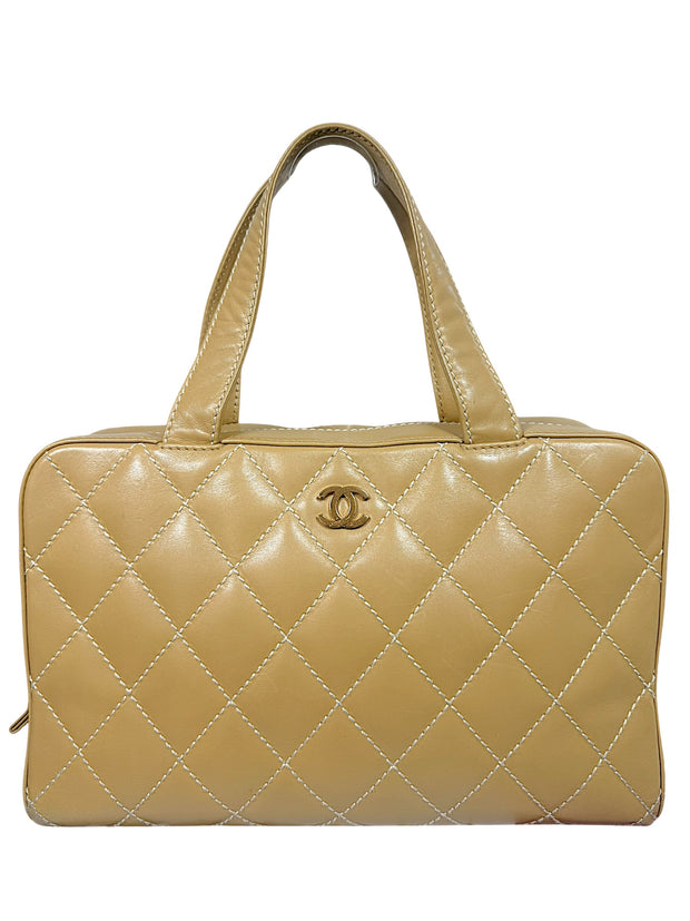 Vintage Chanel Surpique Bowler bag from the 2002–2003 collection in beige quilted lambskin leather with contrast stitching and gold CC logo detail front view.