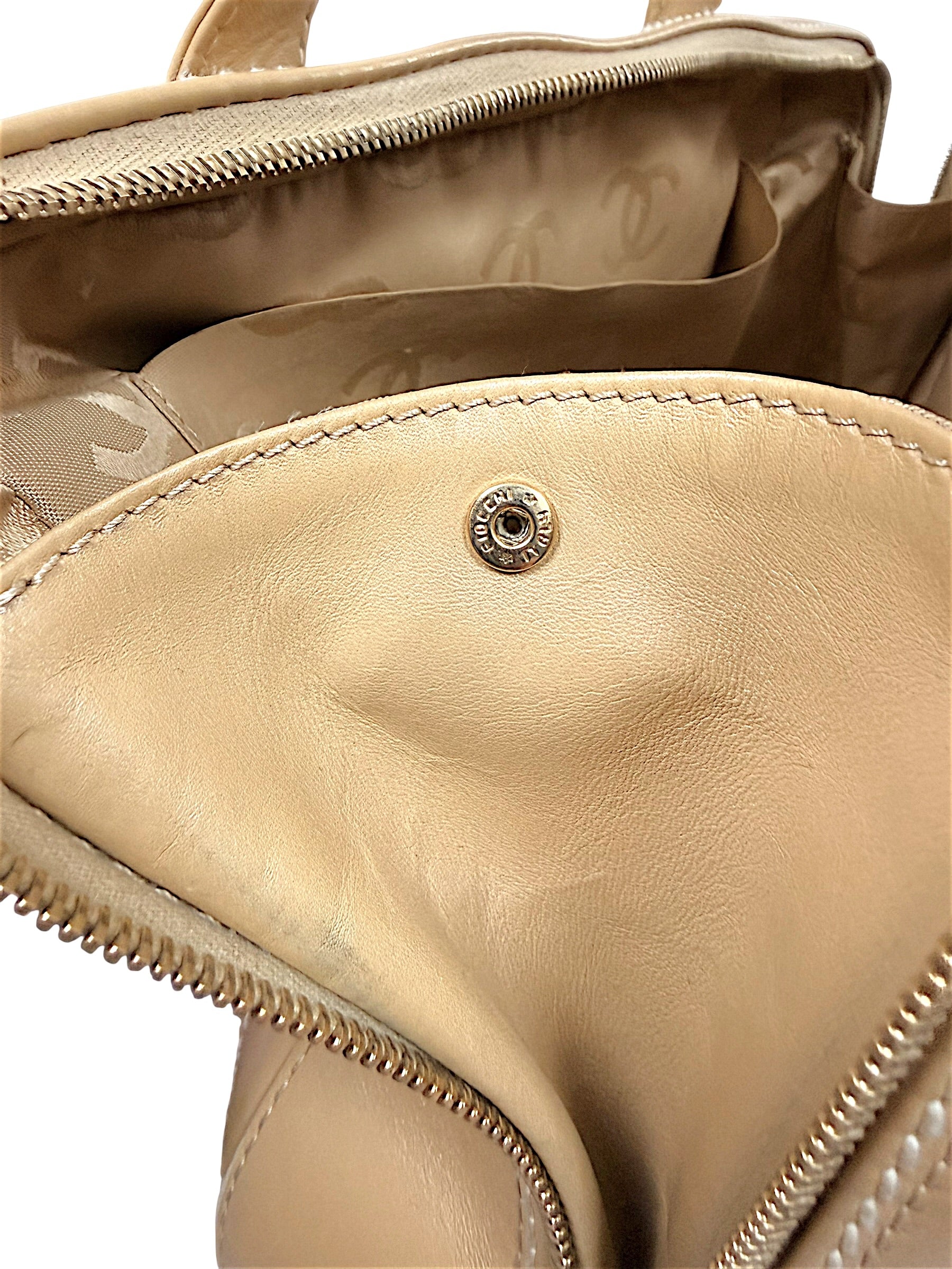 Interior Chanel hardware snap detail inside vintage beige lambskin Surpique Bowler bag.