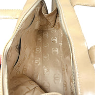 Interior main compartment of Chanel Surpique Bowler bag with beige CC jacquard lining and storage pockets.