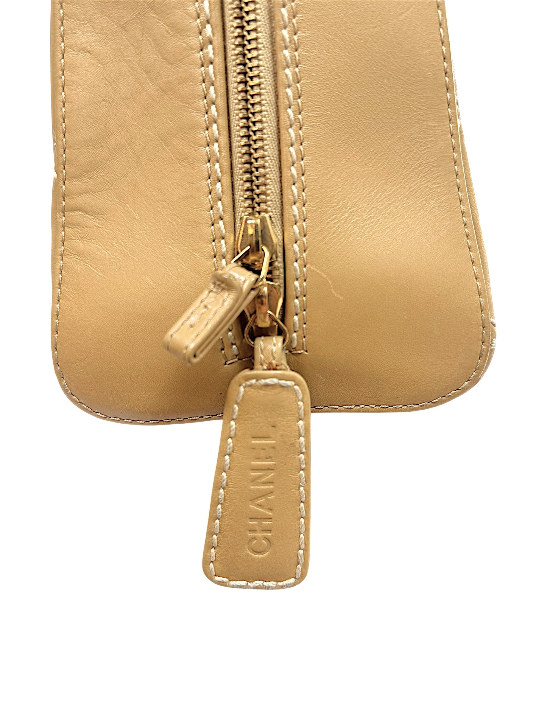Close-up of embossed CHANEL leather zipper pull with contrast stitching on vintage Chanel Surpique Bowler bag.