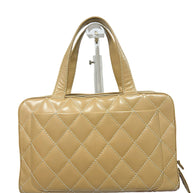 Rear exterior view of Chanel Surpique Bowler bag showing oversized quilting and rolled leather handles.