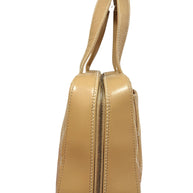 Angled side profile of Chanel vintage Surpique Bowler bag in beige quilted lambskin leather.