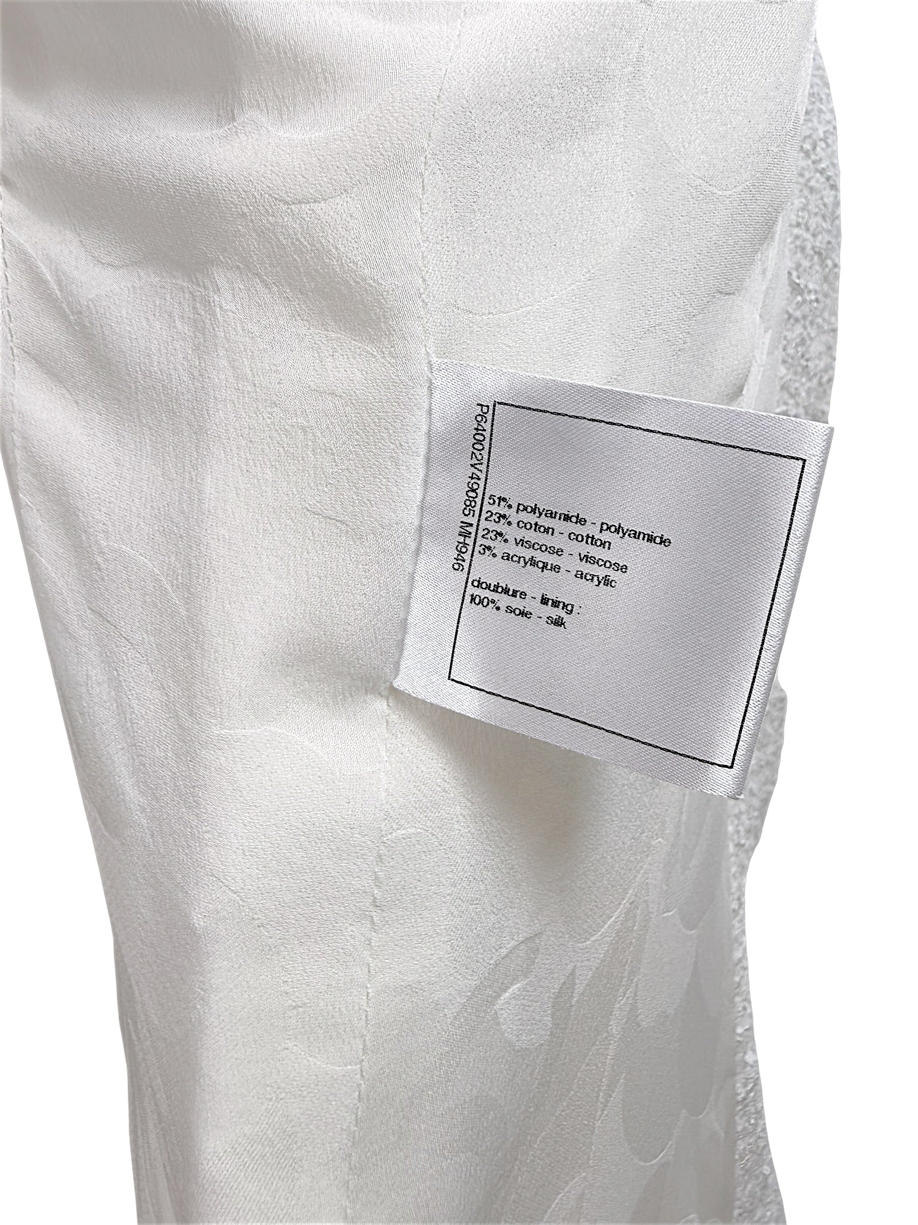 Fabric composition tag inside Chanel white bouclé tweed dress with silk lining and metallic trim