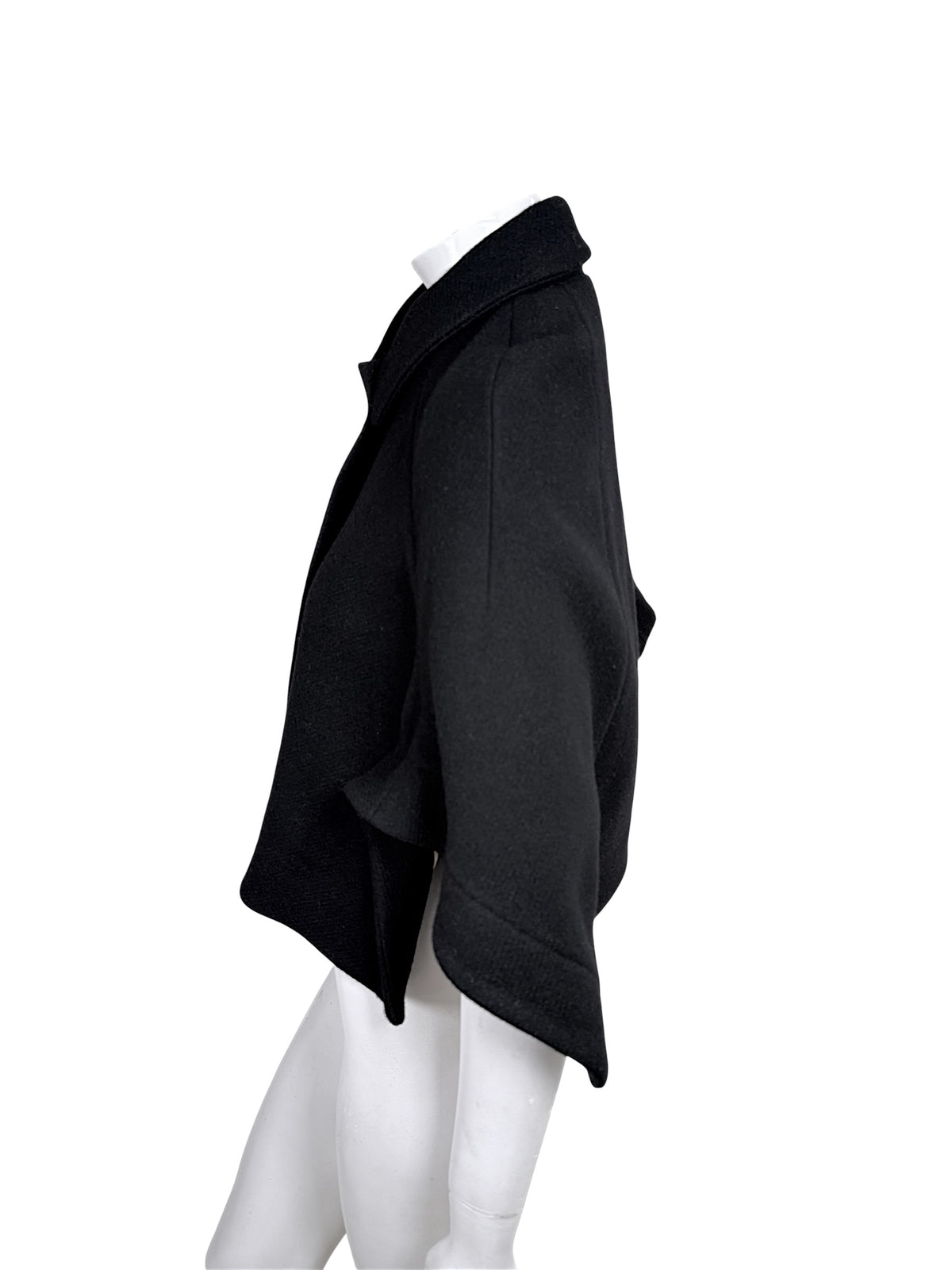 Side silhouette of Chloé Fall 2013 black virgin wool cape jacket with cropped flared sleeve and curved hem