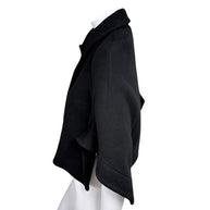 Side silhouette of Chloé Fall 2013 black virgin wool cape jacket with cropped flared sleeve and curved hem