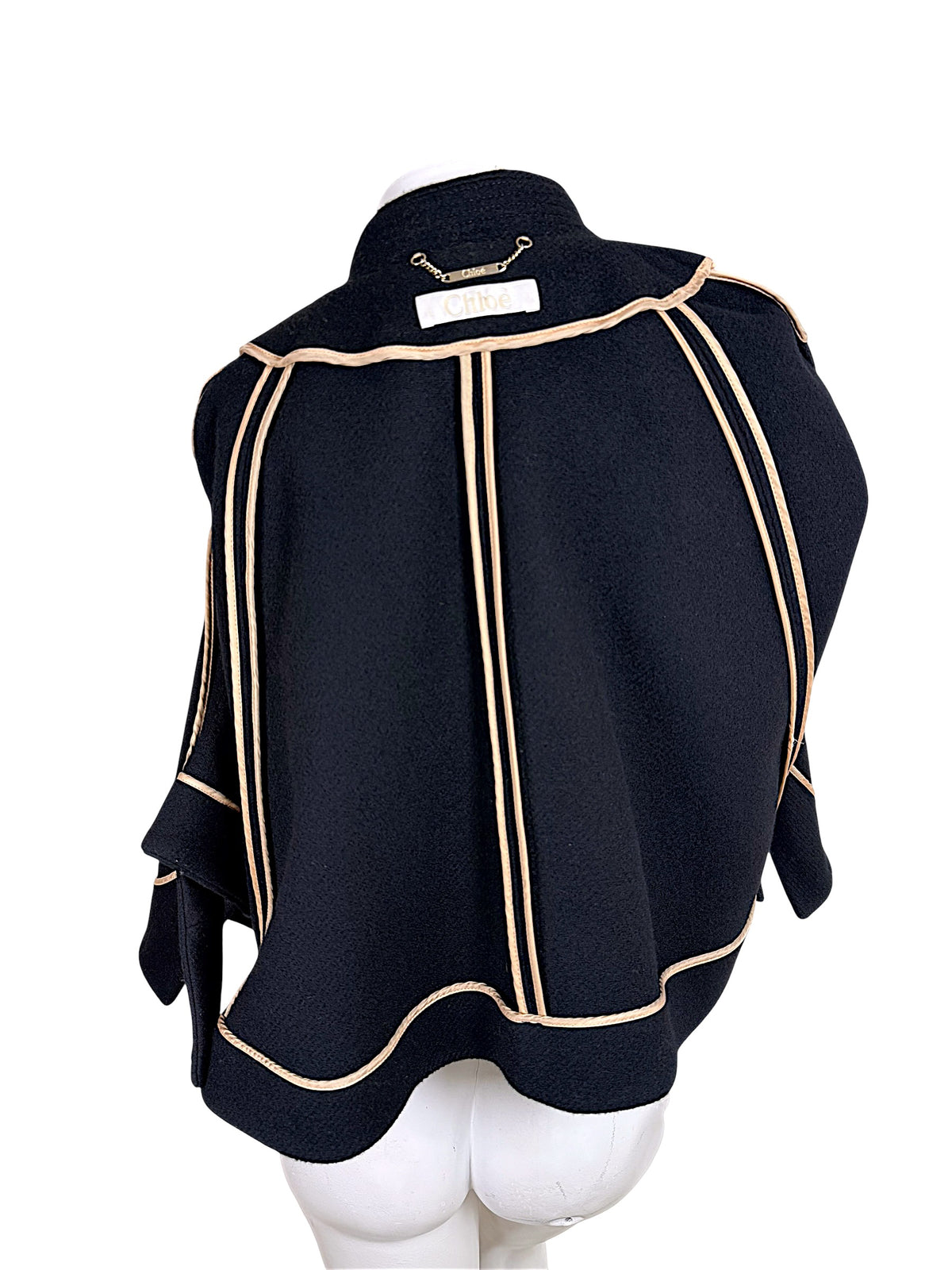 Interior of Chloé black wool cape jacket showing beige grosgrain seam finishing and paneled construction