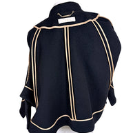 Interior of Chloé black wool cape jacket showing beige grosgrain seam finishing and paneled construction