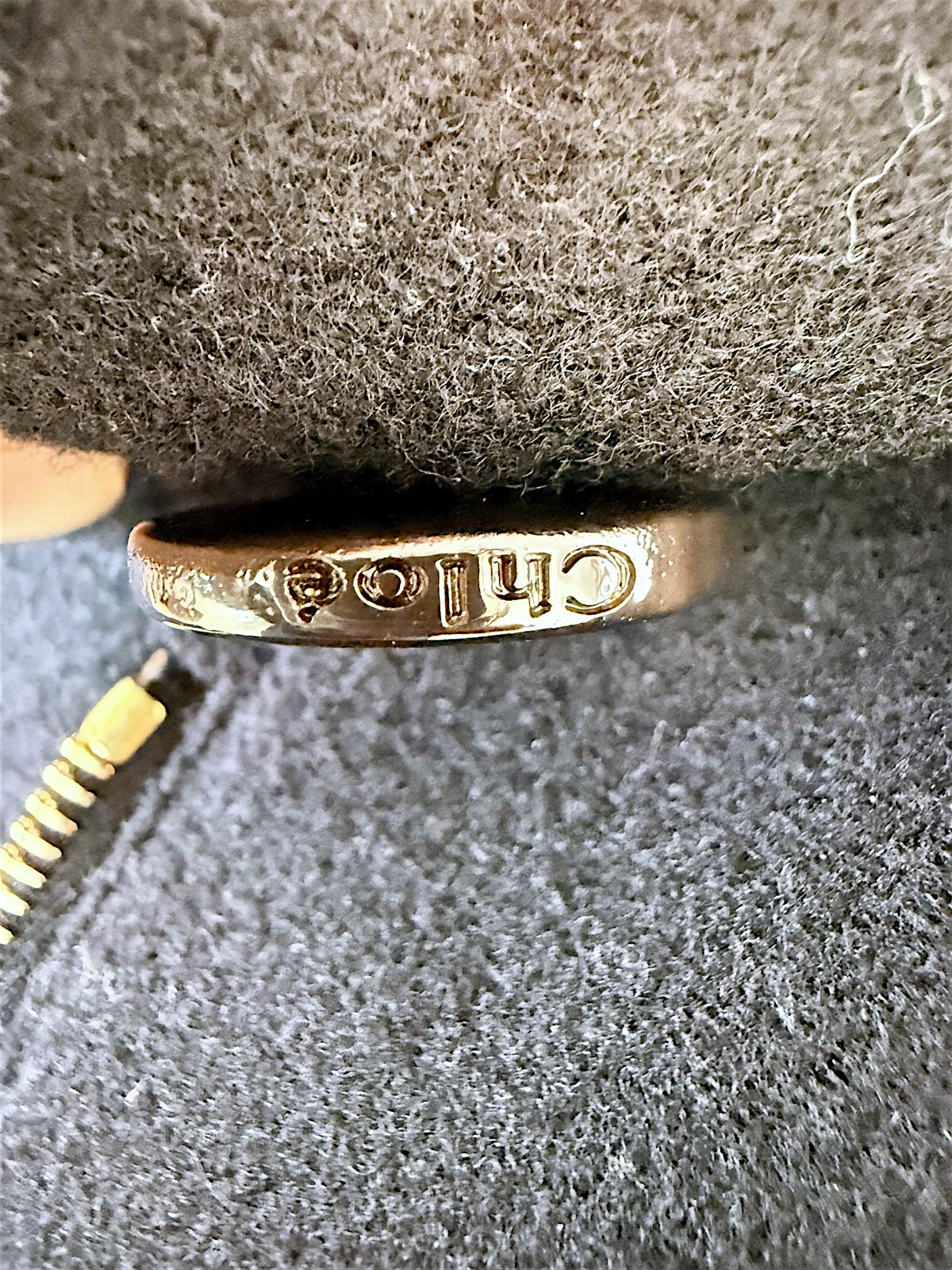 Detail of engraved Chloé button on authentic black wool cropped cape jacket