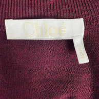 Close-up of Chloé designer label sewn inside the Burnt Mahogany wool tie-front sweater dress from the Fall 2019 collection.