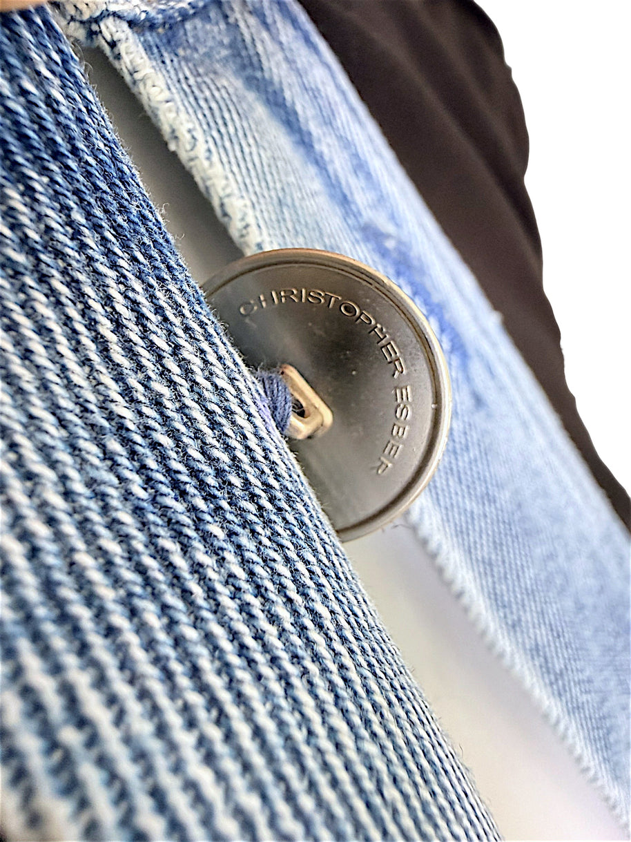 Christopher Esber black maxi dress close-up showing engraved Christopher Esber silver-tone button and blue denim trim detail
