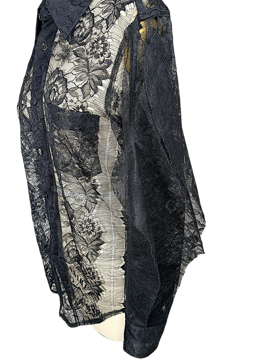 Close-up of Comme des Garçons black floral lace shirt showing chest patch pocket, button placket and delicate transparent botanical lace.