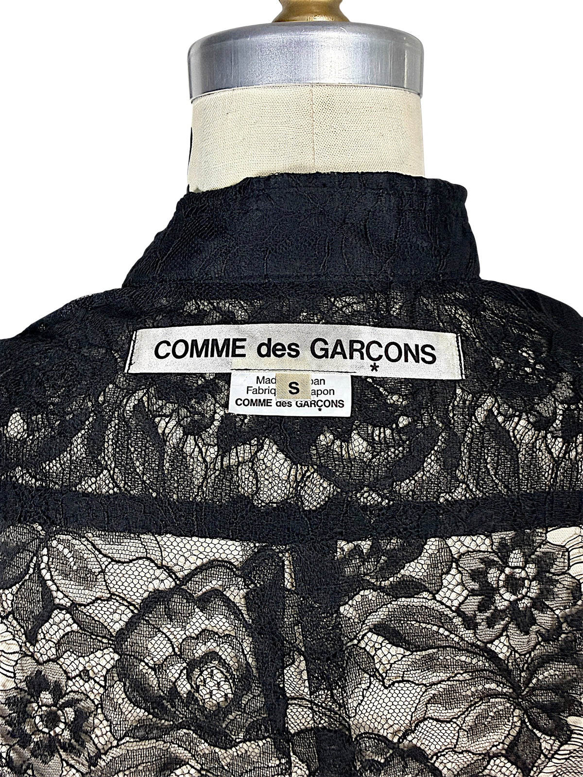 Close-up of original Comme des Garçons mainline designer label and size S tag sewn inside black floral lace shirt, made in Japan.