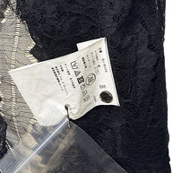 Close-up of Japanese Comme des Garçons shirt care label with style code GJ-B008 and 65 percent cotton, 35 percent nylon composition.
