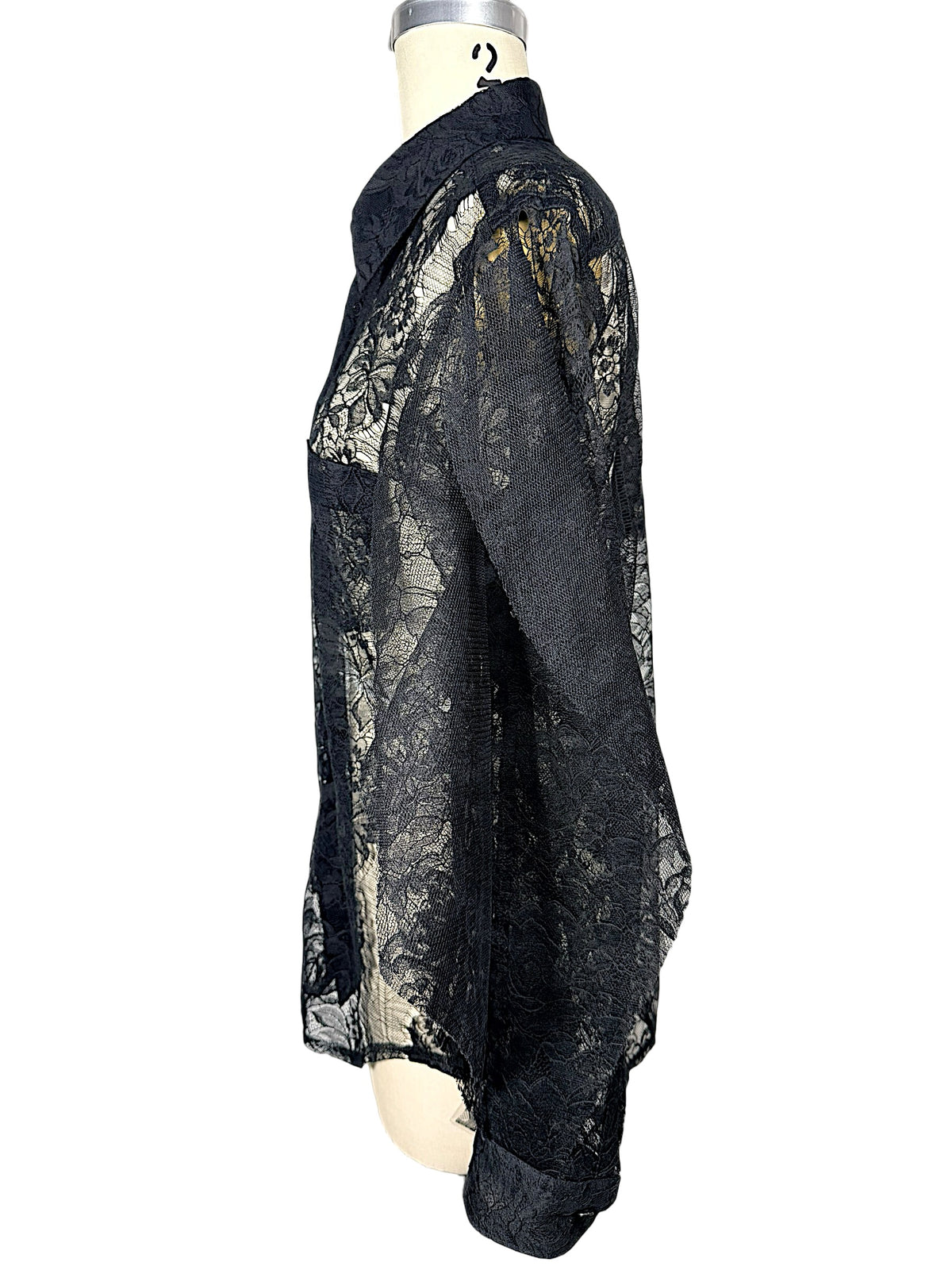 Opposite side view of Comme des Garçons black lace shirt highlighting sheer floral sleeve, pointed collar and relaxed fit.