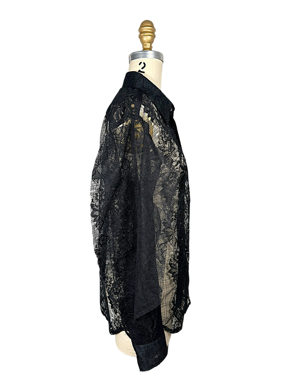 Side profile of Comme des Garçons sheer black floral lace shirt showing relaxed silhouette, transparent sleeves and curved hem.