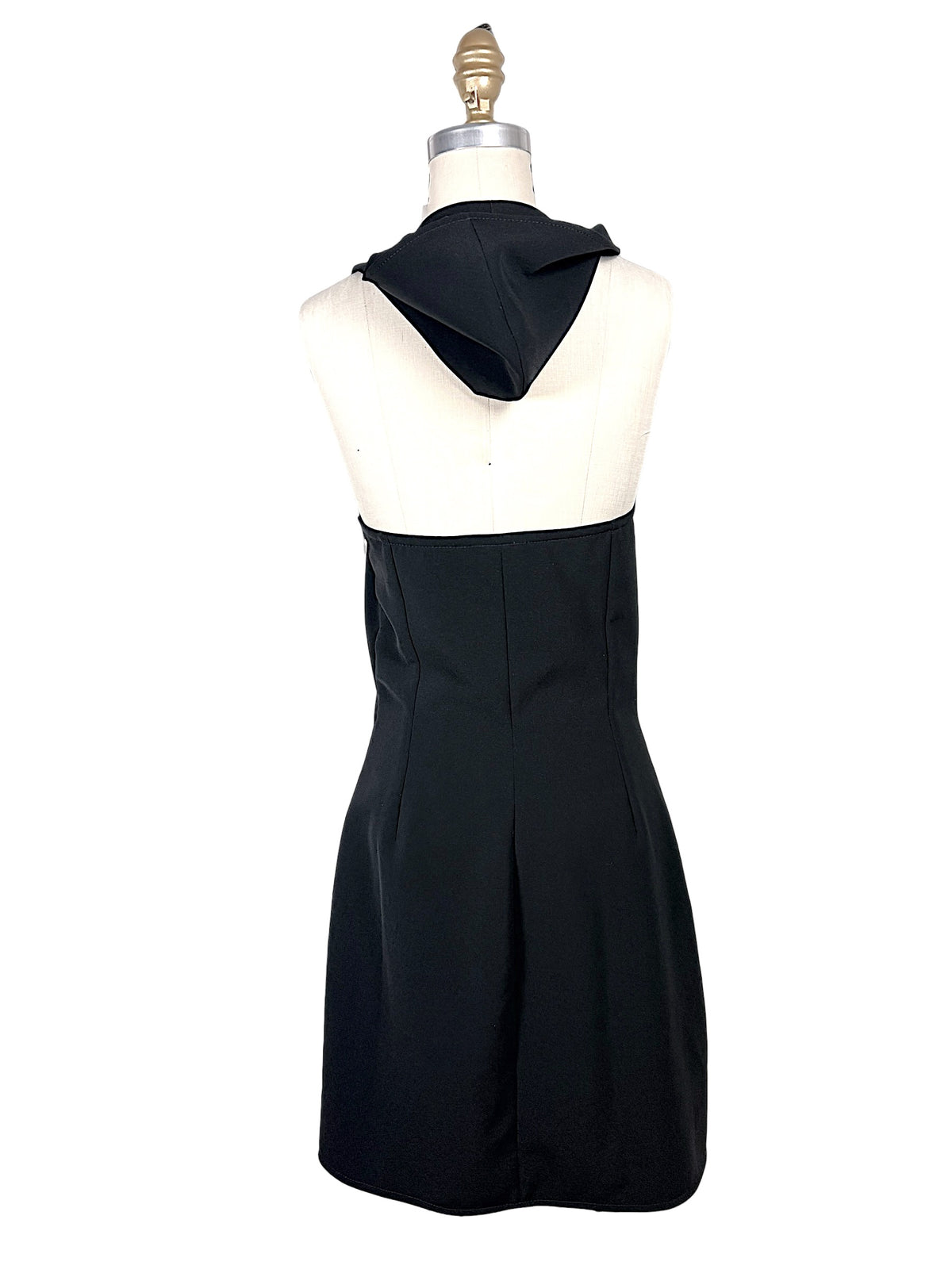 Back view of Courrèges Fall 2024 Oblique Space mini dress with hood lowered, showing the exposed upper back, tailored waist and structured black skirt.