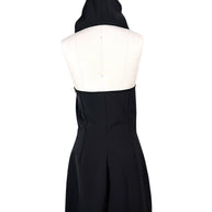 Full back view of Courrèges Fall 2024 Look 23 black Oblique Space mini dress with sculptural hood raised, open upper back and contoured skirt seams.