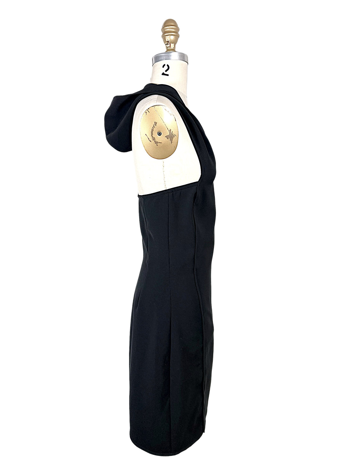 Side profile of Courrèges Fall 2024 Oblique Space black mini dress with hood lowered, revealing the dramatic open upper back and fitted side construction.