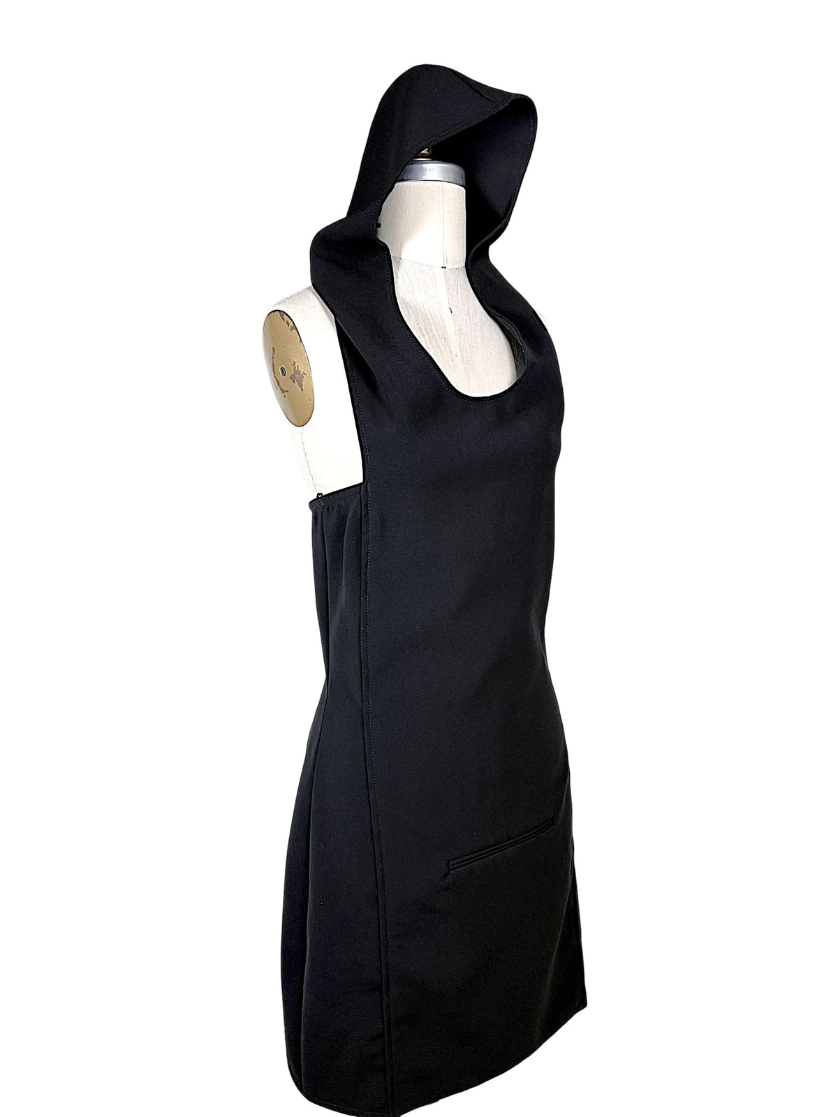 Angled front view of Courrèges Fall 2024 Look 23 black Oblique Space mini dress with oversized hood raised and architectural fitted silhouette.