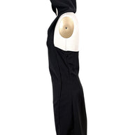 Side profile of Courrèges Fall 2024 Look 23 black Oblique Space mini dress on US size 2 mannequin, showing raised hood, sleeveless cut and fitted silhouette.