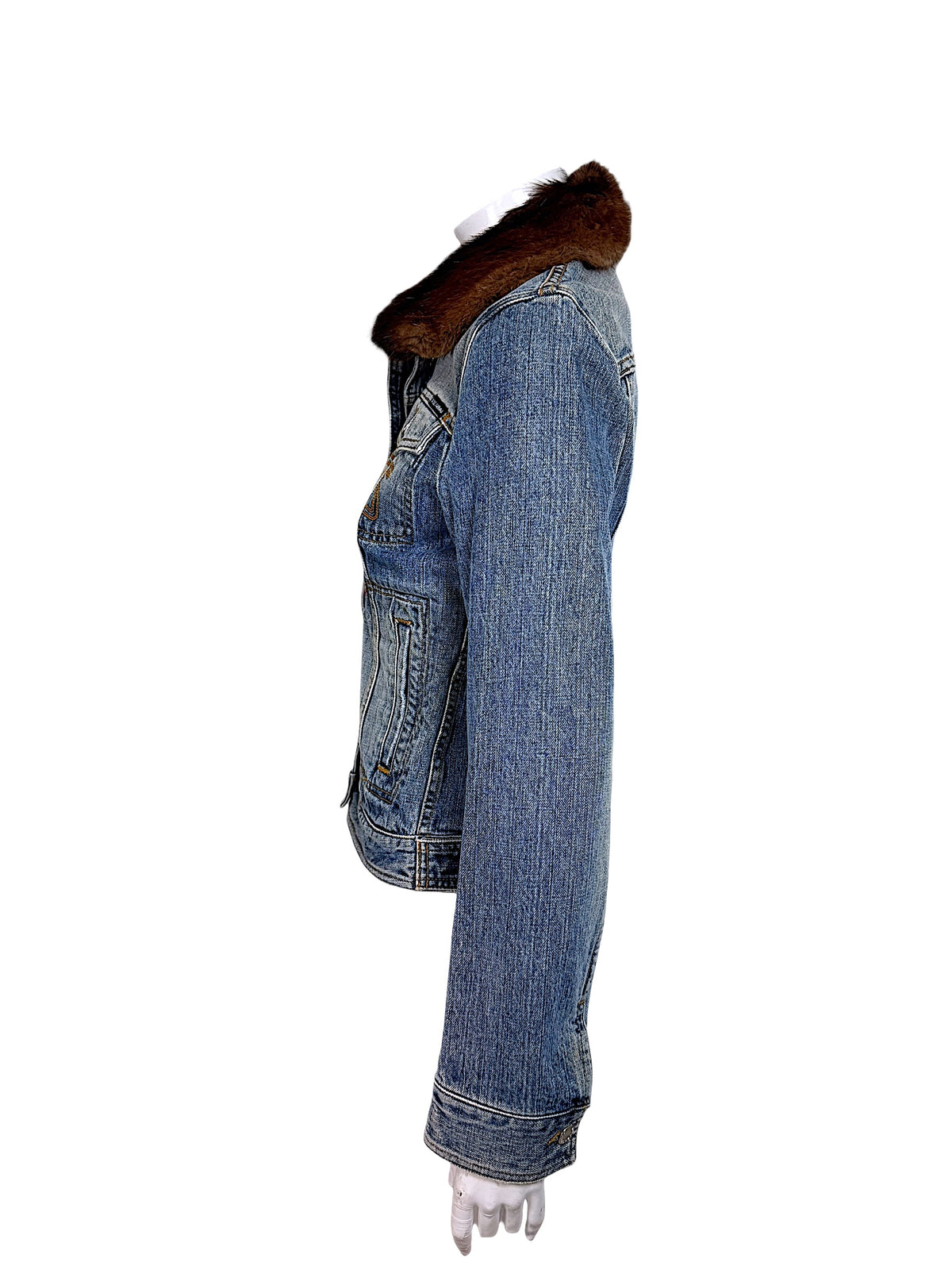 Side view of Dolce & Gabbana vintage denim jacket displaying the long sleeve, contrast stitching, structured shoulder, brown fur collar, and fitted body.