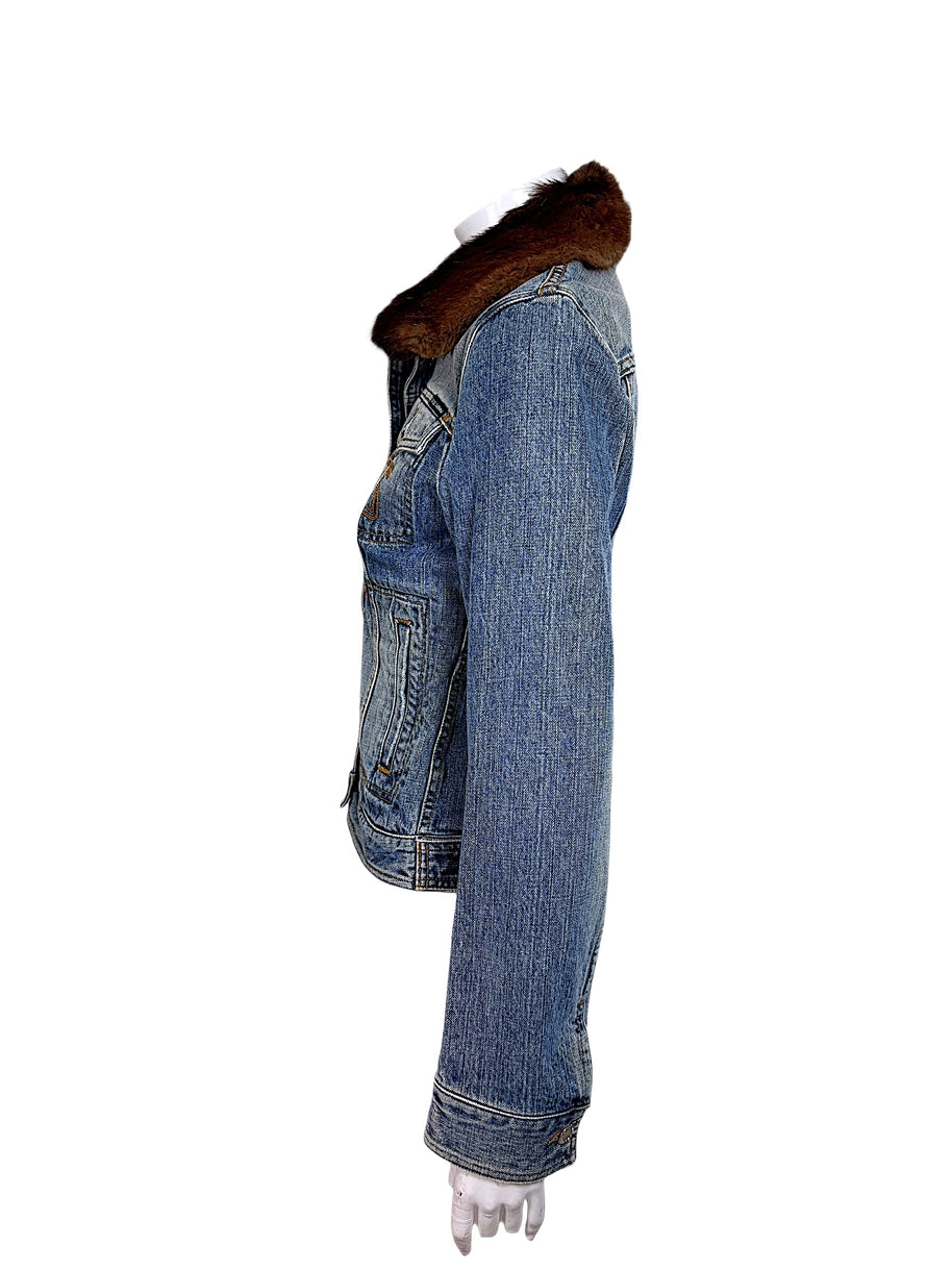 Side view of Dolce & Gabbana vintage denim jacket displaying the long sleeve, contrast stitching, structured shoulder, brown fur collar, and fitted body.