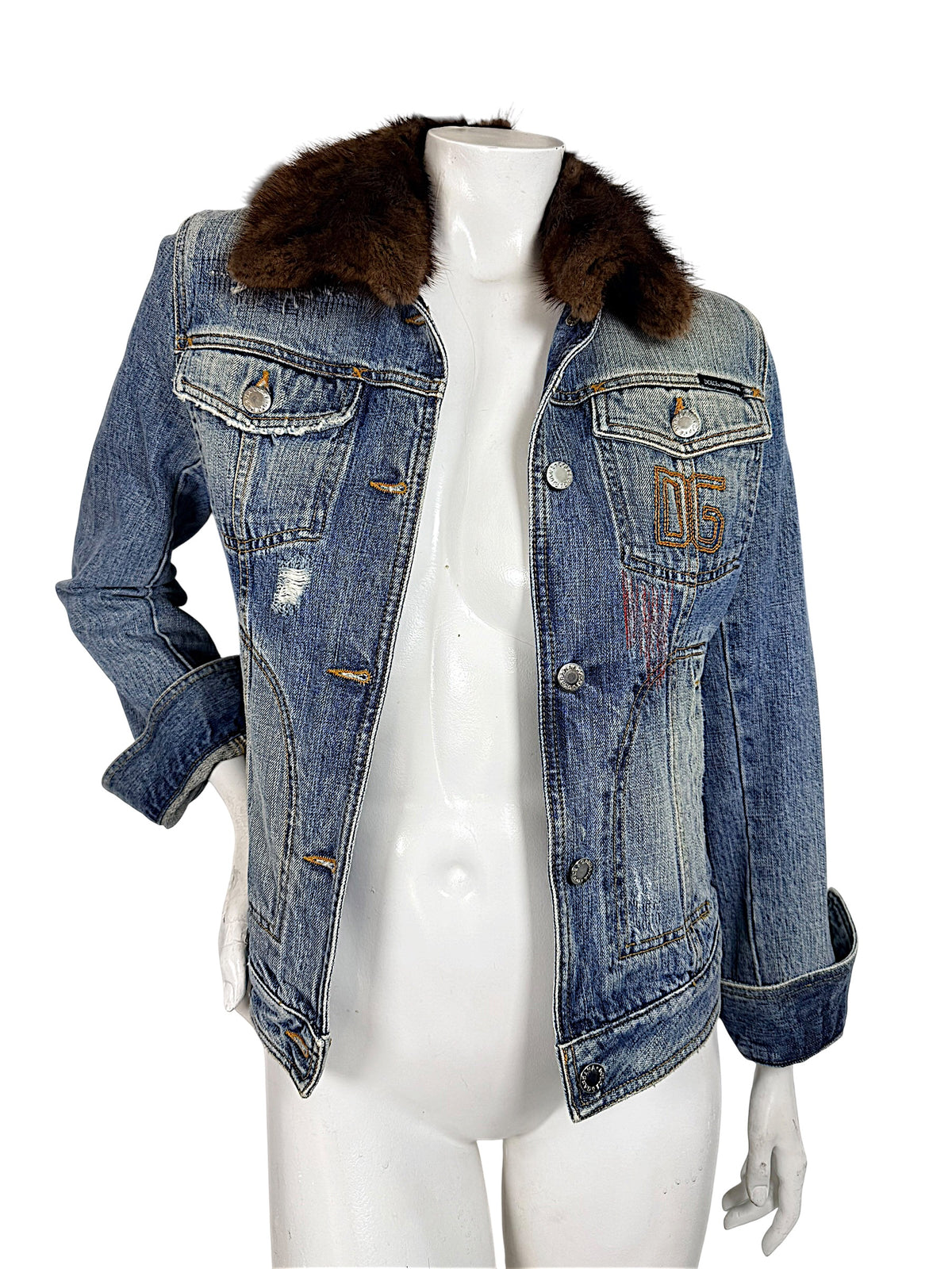 Vintage Dolce & Gabbana blue distressed denim jacket worn open, featuring a plush brown fur collar, embroidered chest detail, and fitted silhouette.