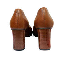 Rear view of Gucci brown leather block heel pumps showing stacked wood-effect heels and pebbled leather construction.