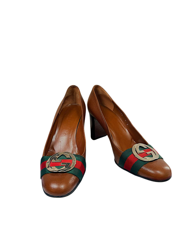 Authentic Gucci brown pebbled leather block heel pumps with signature green and red Web stripe and oversized interlocking GG hardware, angled front view.