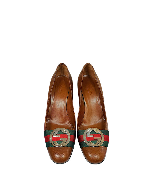 Front view of authentic Gucci brown leather pumps featuring green and red Web stripe detail and polished interlocking GG logo hardware.