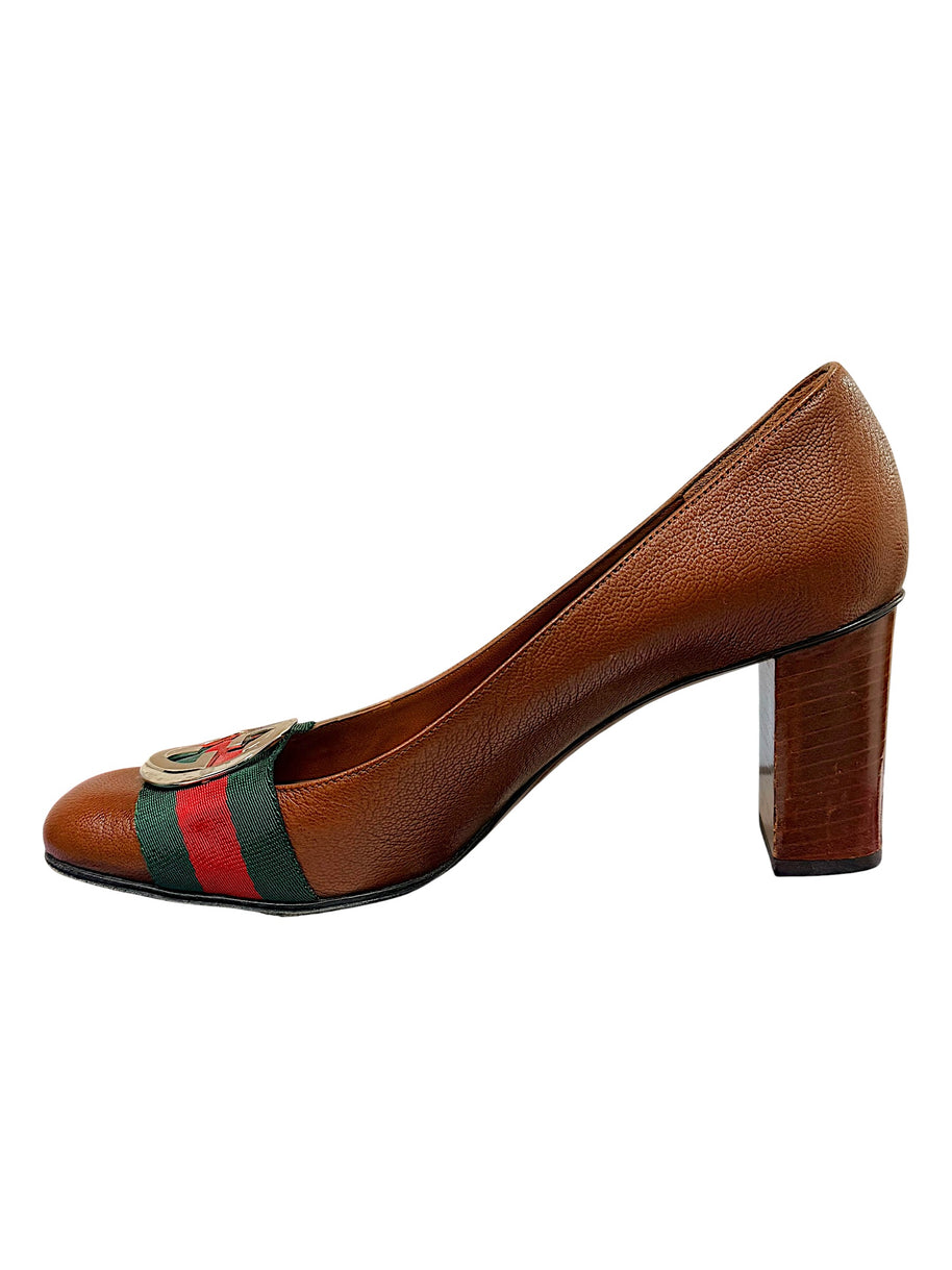 Side profile view of Gucci brown leather block heel pumps with iconic Web stripe detailing and interlocking GG hardware.