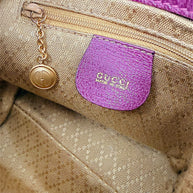 Interior zip pocket and Gucci logo charm inside vintage bamboo bag