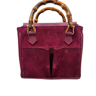 Front view of vintage Gucci magenta suede bamboo handle handbag