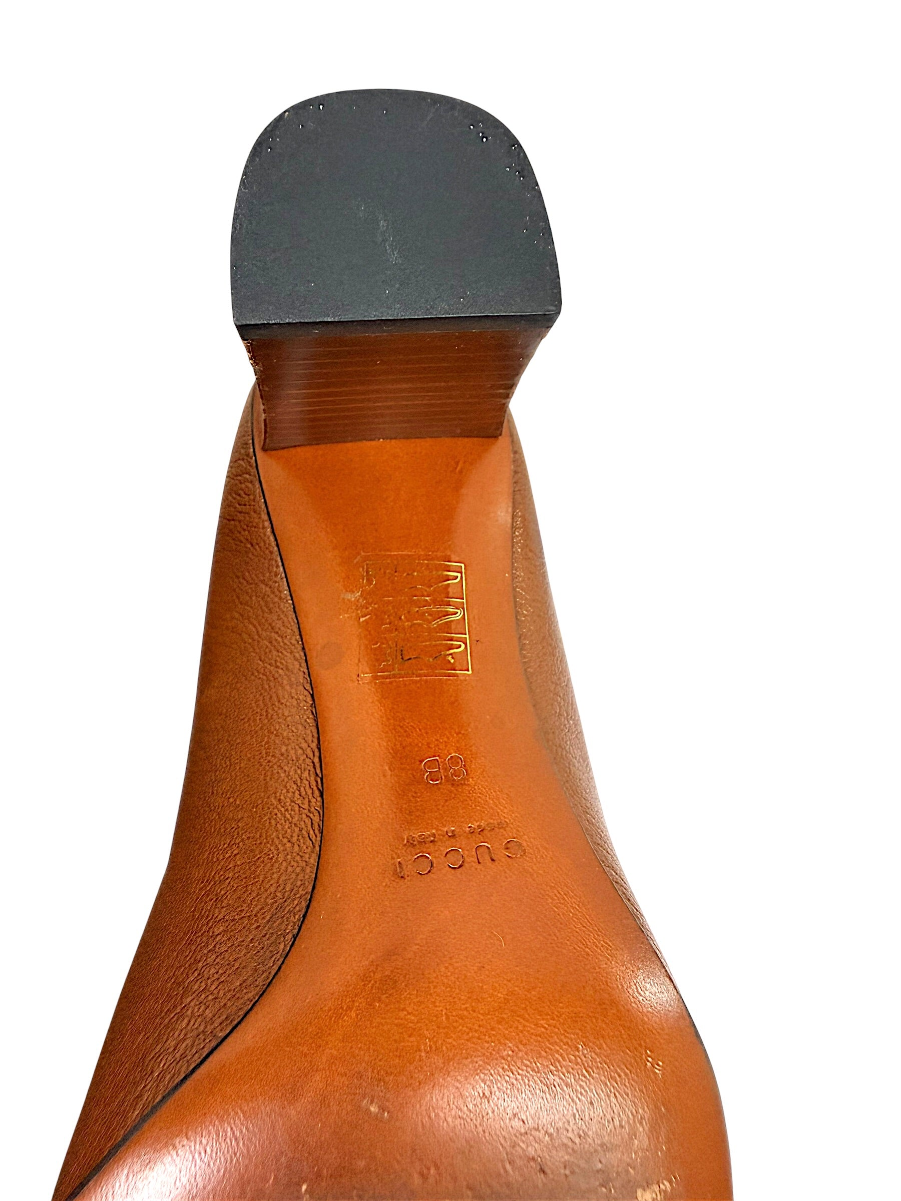 Close-up detail of Gucci block heel and leather sole construction showing heel cap and condition.