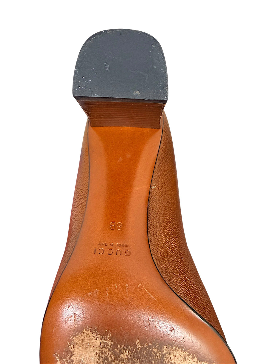 Detailed heel and sole close-up of authentic Gucci brown leather pumps.