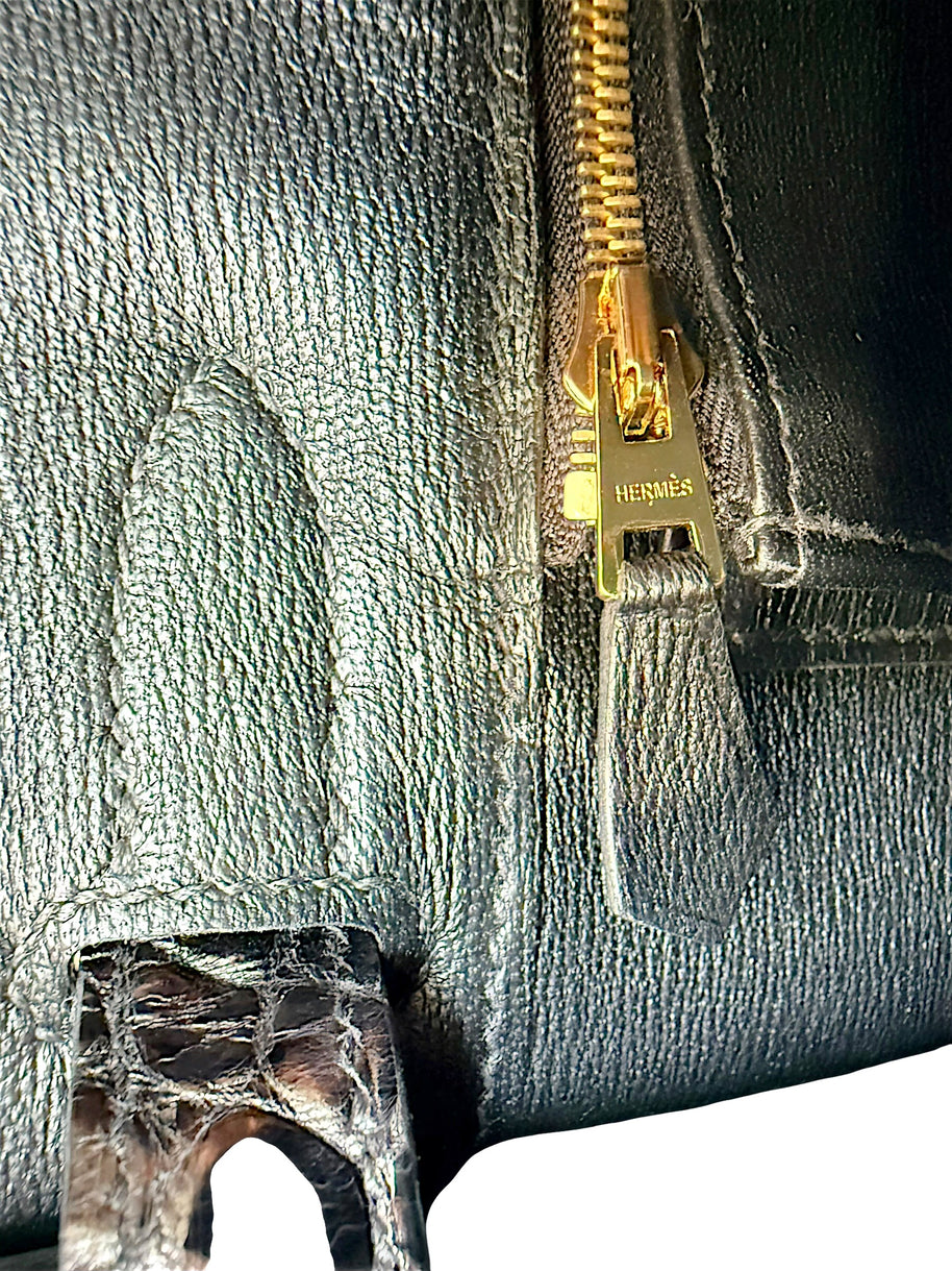 Close-up detail of Hermès branded gold zipper pull inside black crocodile Birkin 30 handbag