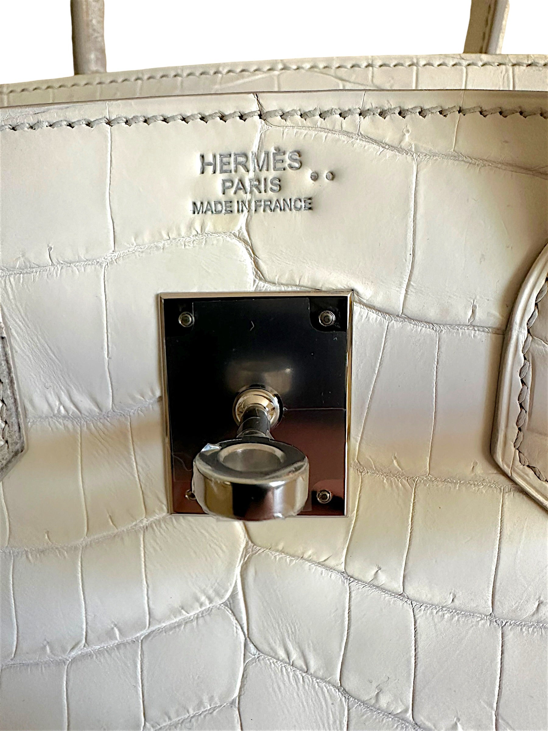 Close-up Hermès Paris Made in France embossing and palladium turnlock hardware detail on Himalaya Birkin 30.