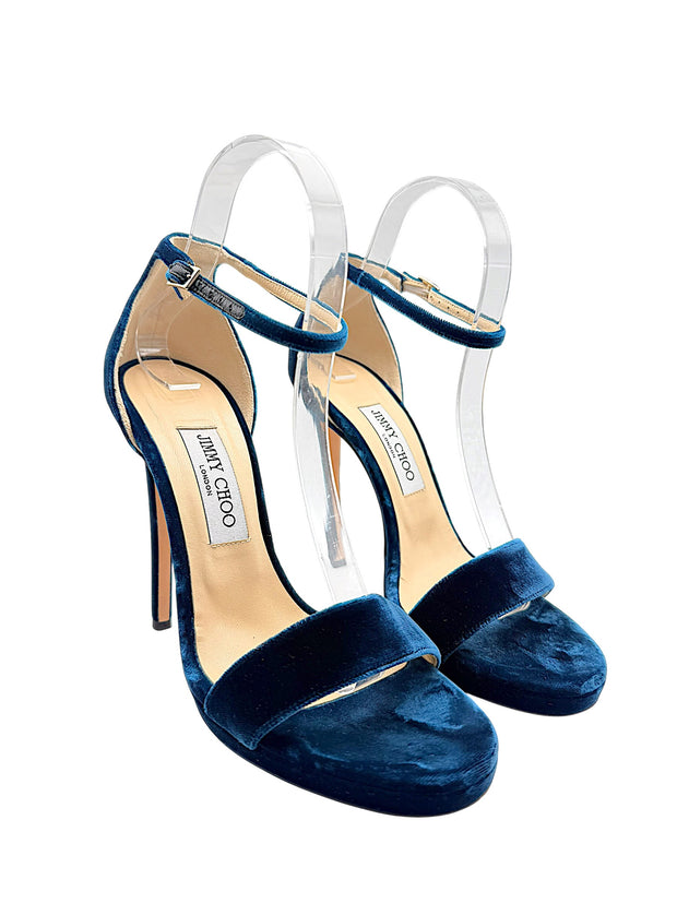 Three-quarter view of Jimmy Choo Misty 120 peacock blue velvet platform heels showing adjustable ankle buckles, open toes and covered stilettos.