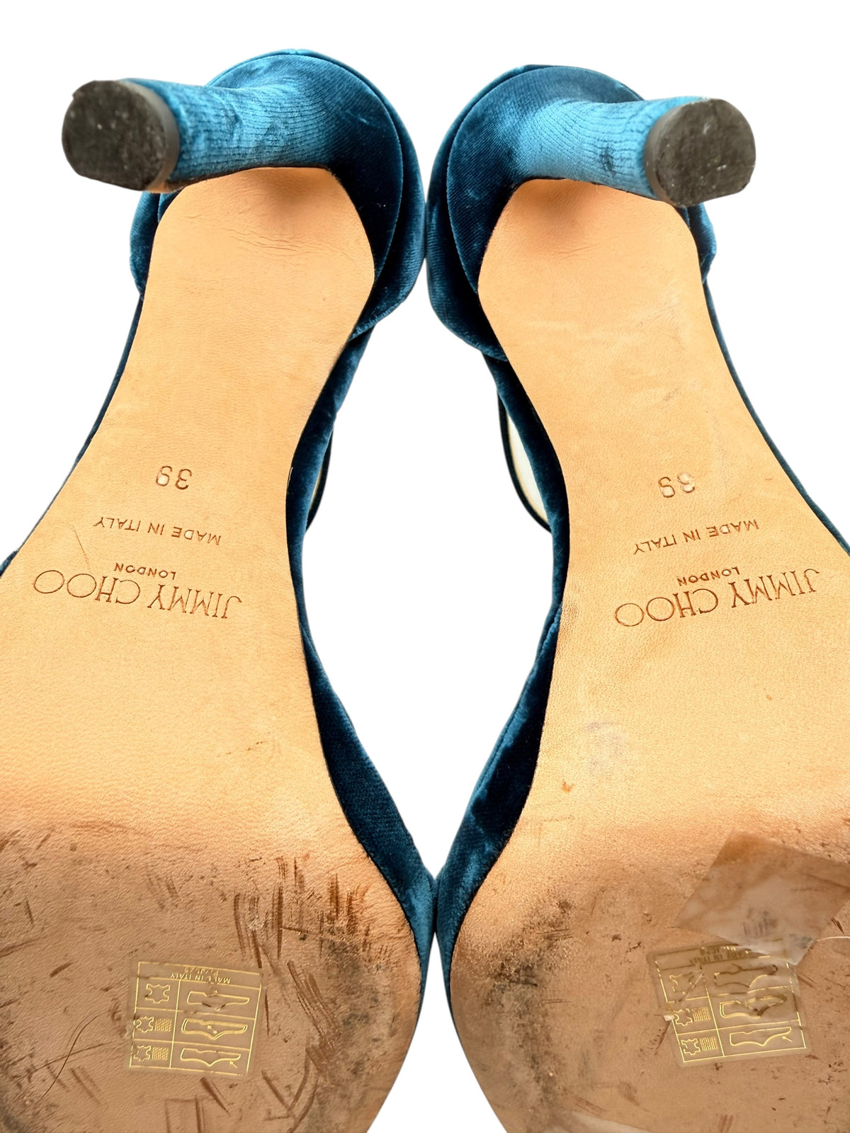 Close-up of Jimmy Choo Misty 120 teal velvet stiletto heel tips and leather soles showing original branding, size 39 and signs of use.